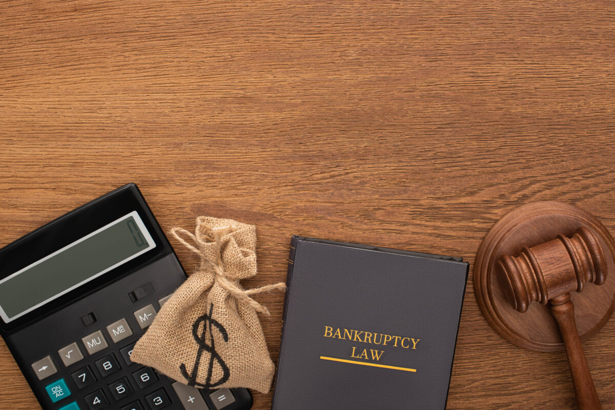 Bankruptcy law book with money bag, gavel, and calculator