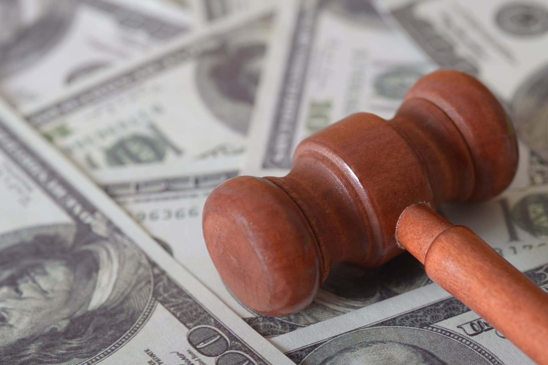 Wooden gavel placed on top of US dollar bills