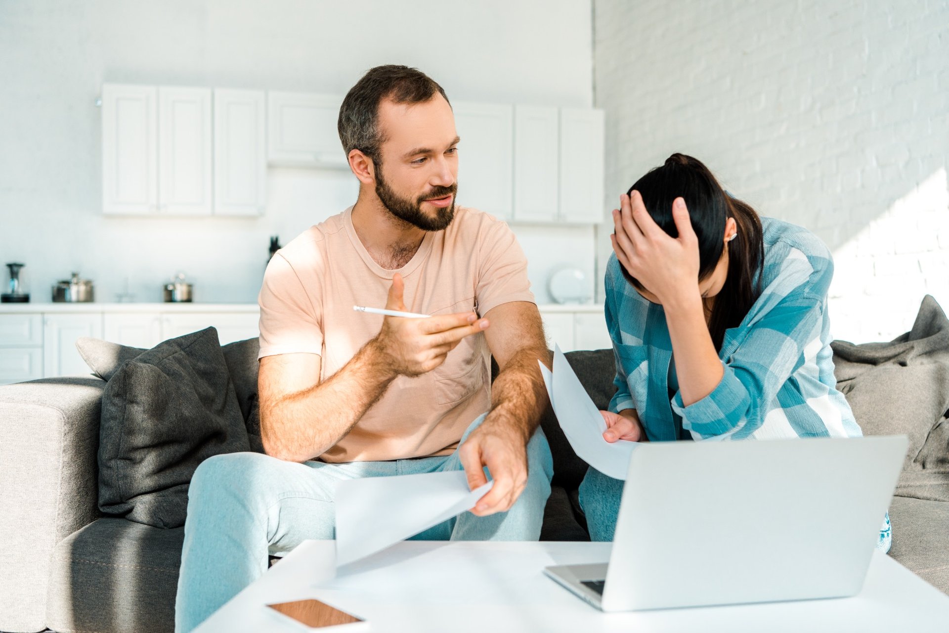 man explaining paperwork while partner feels defeated