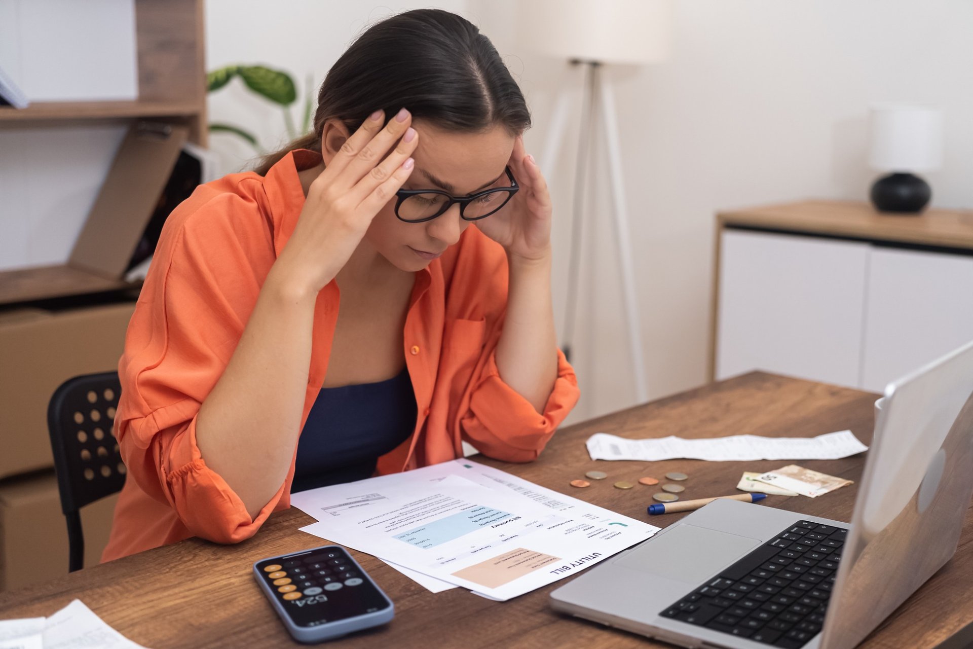 Young woman reviewing utility bills in frustration