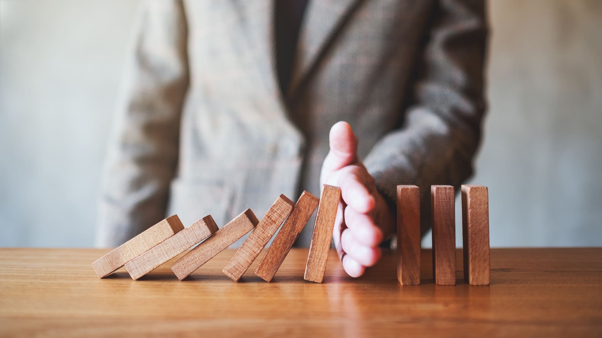 illustration of lawyer stopping debt spiral by stopping falling dominos