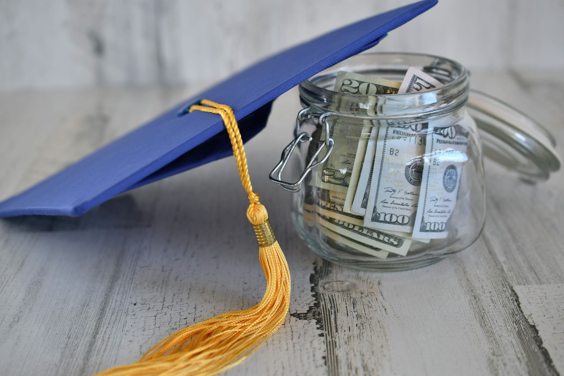 Graduation cap on top of jar of money