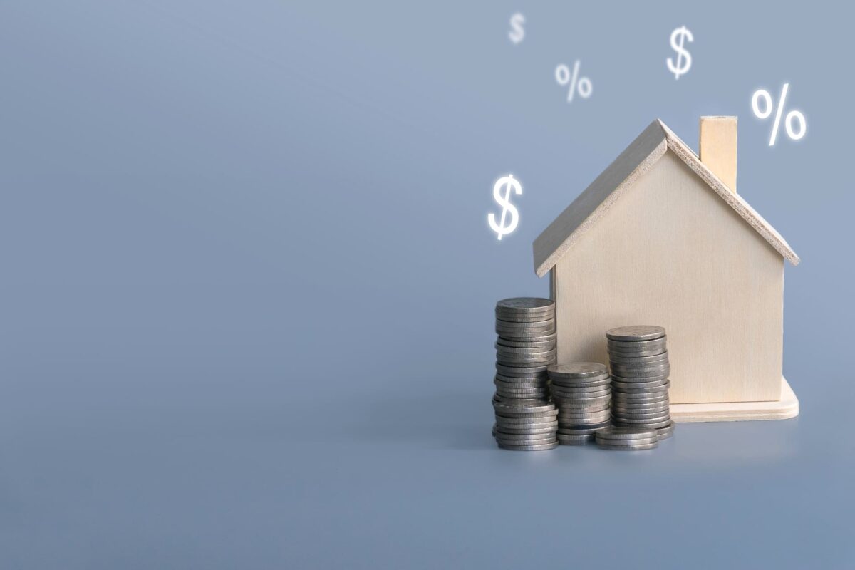stack of coins and a papercut house