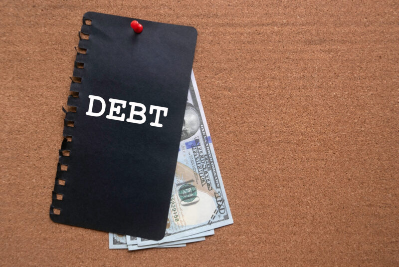 black debt notepad with hundred dollar bills