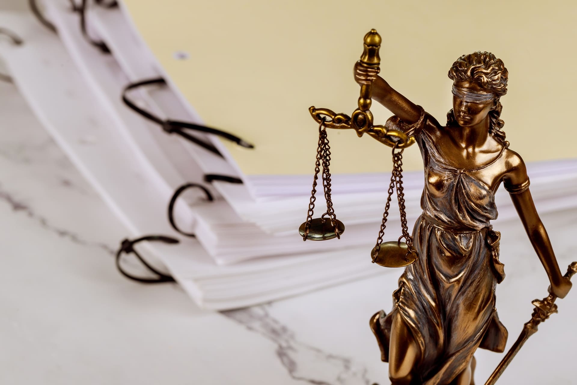 lady justice in front of piles of documentation