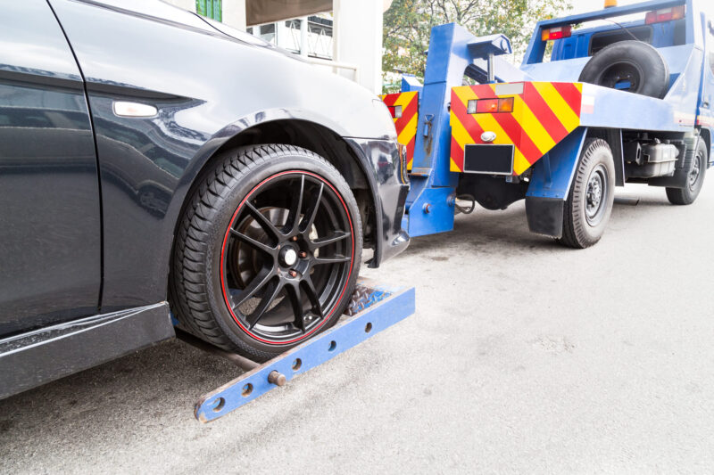 tow-truck-towing-a-broken-down-car-on-the-street