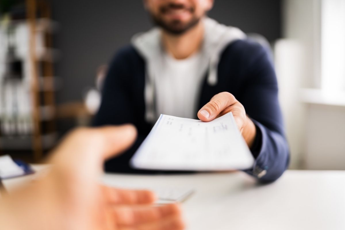 man handing a paycheck